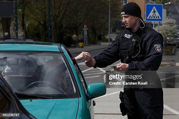 German policeman checks the vehicle documents of a motorist near the Polish border on April 15, 2014 in Frankfurt an der Oder, Germany. May 1 will...