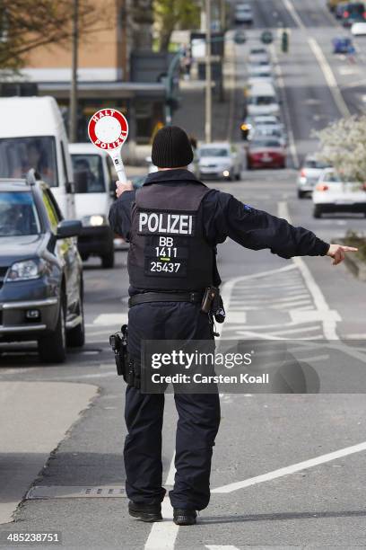 German policman holds a police signal stick to stop cars to check their vehicle papers and contents near the Polish border on April 15, 2014 in...