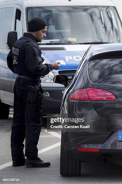 German policeman checks the vehicle documents of a motorist near the Polish border on April 15, 2014 in Frankfurt an der Oder, Germany. May 1 will...