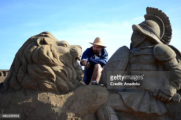 Sand sculptor carves his work, Gladiator fighting with a lion, at Lara Beach on April 17, 2014 in Antalya, Turkey. 25 sculptors from 12 countries...
