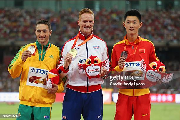 Silver medalist Fabrice Lapierre of Australia, gold medalist Greg Rutherford of Great Britain and bronze medalist Jianan Wang of China pose on the...