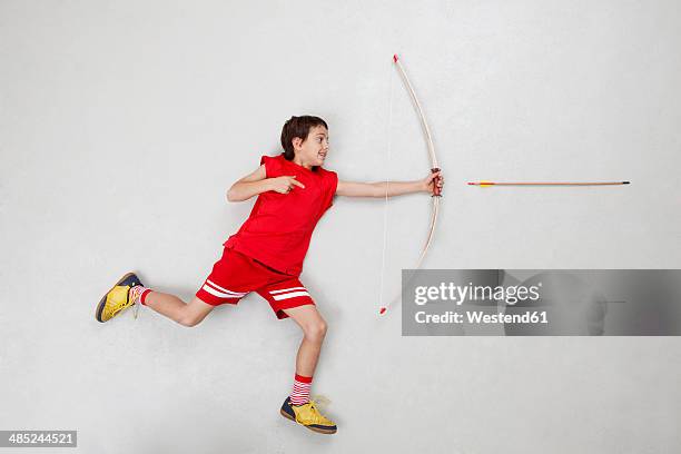 boy shooting with bow and arrow - arco frecce foto e immagini stock