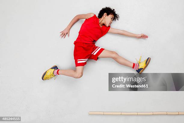 boy doing long jump - long jump photos et images de collection