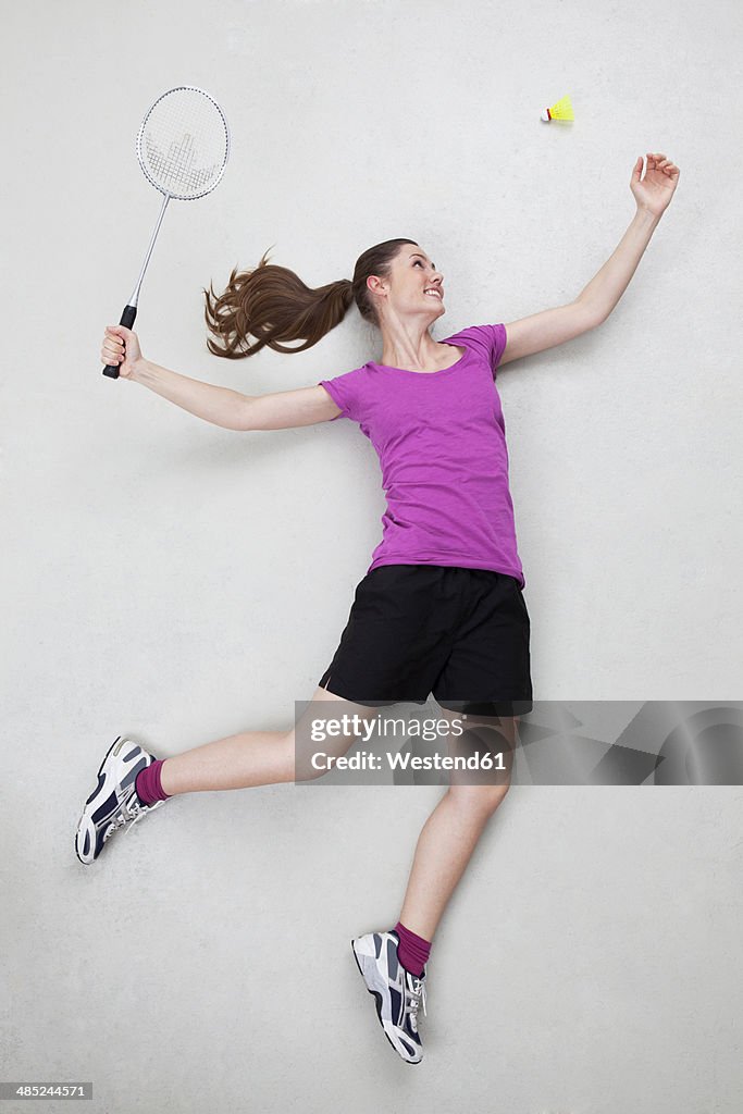 Batminton player serving shuttlecock