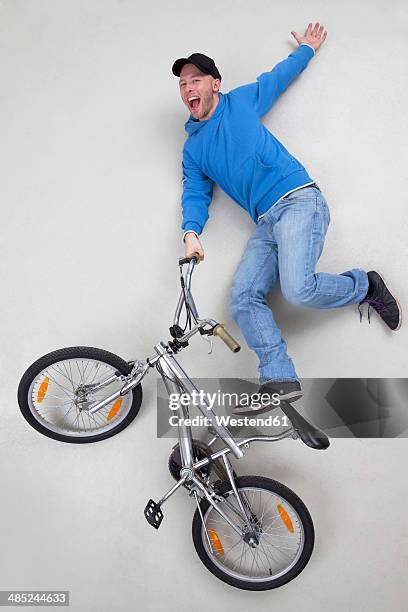 man doing stunt on bicycle - bicycle stunt stock pictures, royalty-free photos & images