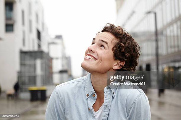 portrait of young man looking up - man looking up photos et images de collection