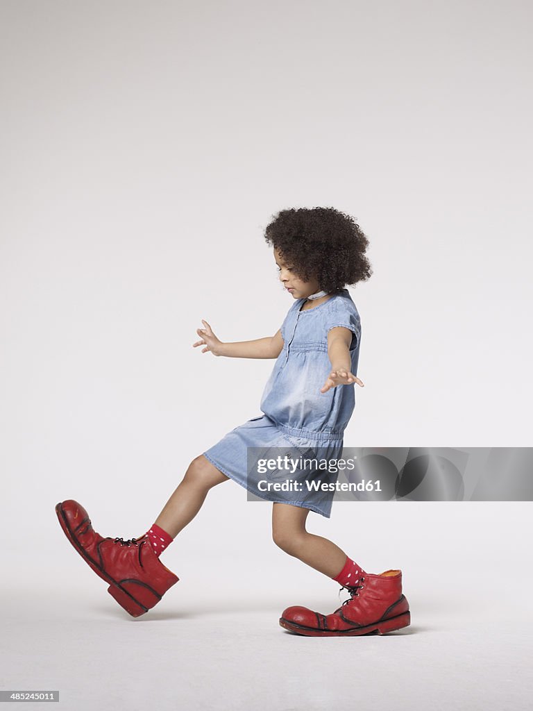 Girl walking in large clown shoes