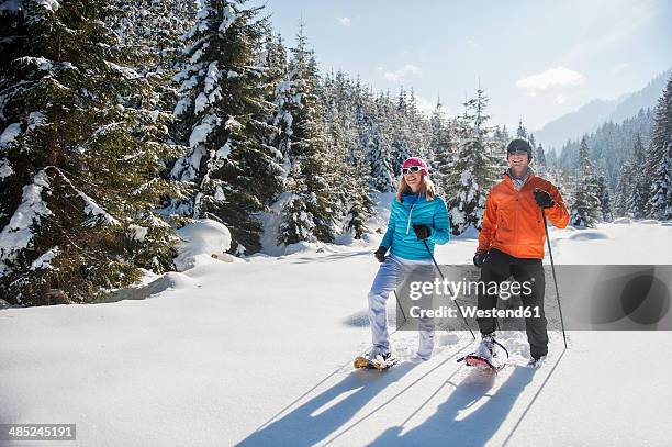 austria, salzburg state, altenmarkt-zauchensee, couple snowshoeing in winter landscape - schneeschuh stock-fotos und bilder