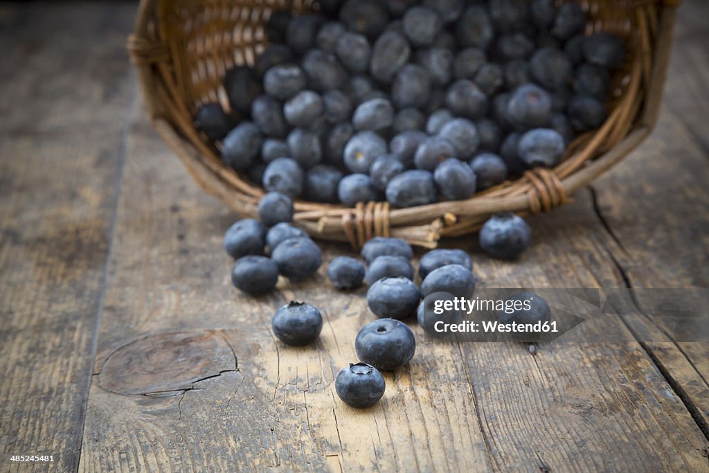 Part of wickerbasket with blueberries (Vaccinium myrtillus) on wooden table