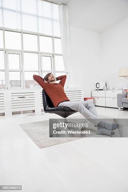 germany, munich, man at home, sitting in chair, hands behind head - men in white socks 個照片及圖片檔