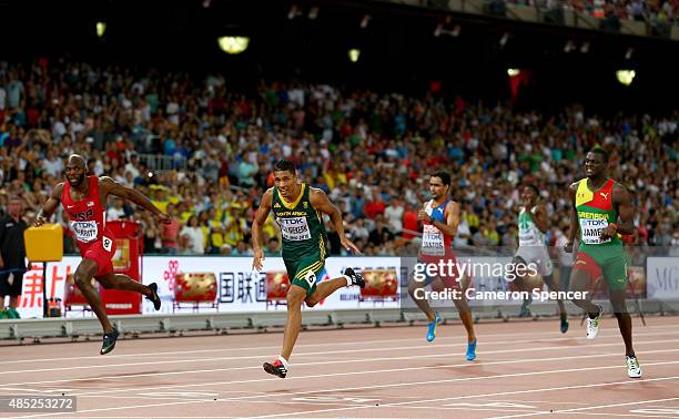 Wayde Van Niekerk of South Africa crosses the finish line to win gold ahead of Lashawn Merritt of the United States and Kirani James of Grenada in...