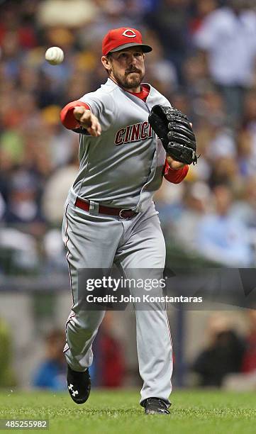 Sam LeCure of the Cincinnati Reds throws out a runner during the seventh inning of their game against the Milwaukee Brewers at Miller Park on...