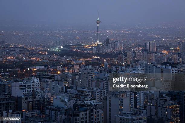 The Milad Tower, top center, also known as the Tehran Tower, stands illuminated beyond residential and commercial properties on the city skyline i in...