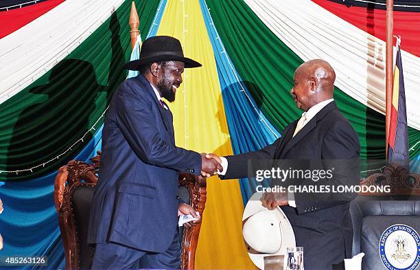 South Sudan's President Salva Kiir shakes hands with Uganda's President Yoweri Museveni after signing a peace agreement in Juba, on August 26, 2015....