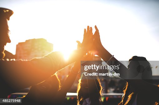 Glückliche Freunde auf dem Dach zu tun, dass sich ein high five gibt Glückliche Freunde auf dem Dach zu tun, dass sich ein high five gibt