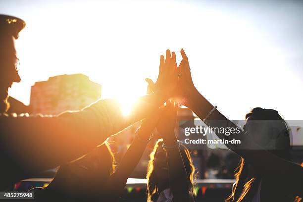 happy friends at the rooftop doing high five - sunset city stock pictures, royalty-free photos & images