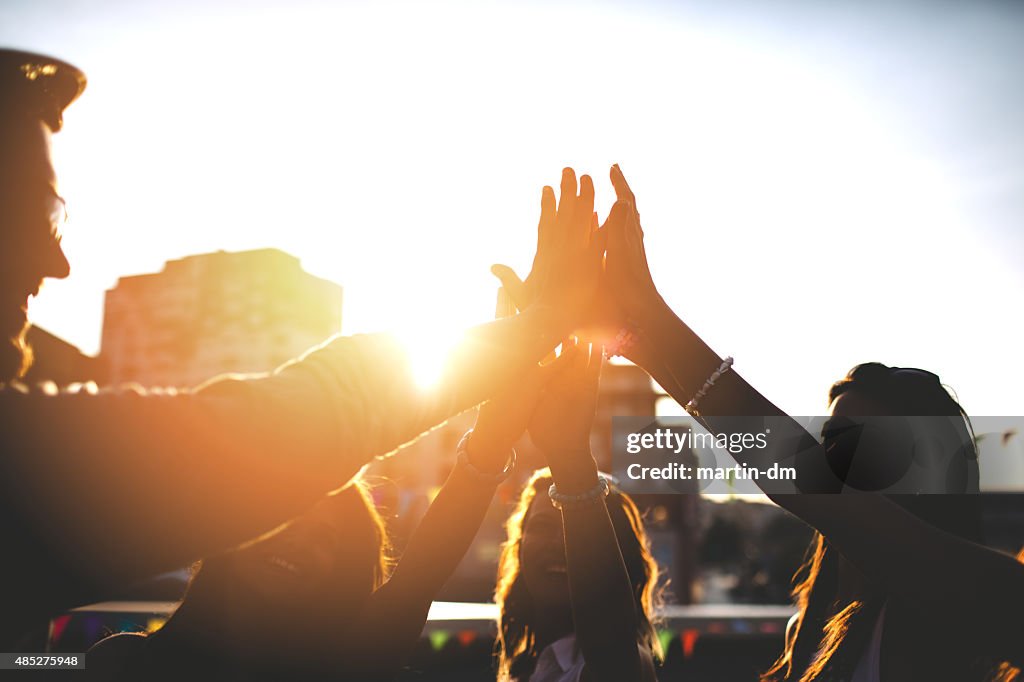 Happy friends at the rooftop doing high five