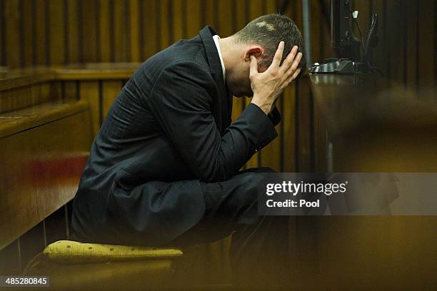 Oscar Pistorius on his cell phone while sitting in the dock in the Pretoria High Court on April 17 in Pretoria, South Africa. Oscar Pistorius stands...