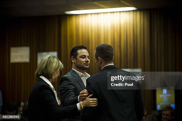 Oscar Pistorius is comforted by brother, Carl Pistorius in the Pretoria High Court on April 17 in Pretoria, South Africa. Oscar Pistorius stands...