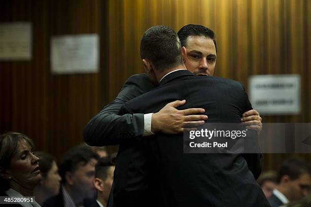 Oscar Pistorius is comforted by brother, Carl Pistorius in the Pretoria High Court on April 17 in Pretoria, South Africa. Oscar Pistorius stands...