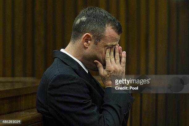 Oscar Pistorius on his cell phone while sitting in the dock in the Pretoria High Court on April 17 in Pretoria, South Africa. Oscar Pistorius stands...