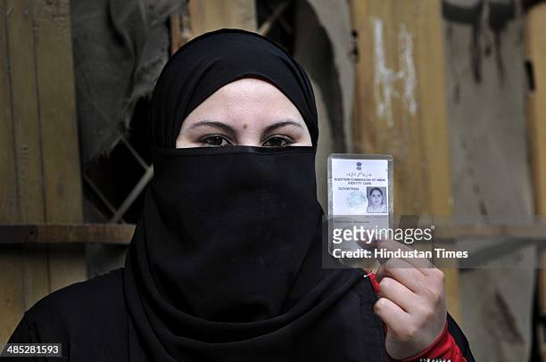 Muslim girl showing her voter ID card after cast her vote at a polling station set up inside a school at Doda on April 17, 2014 in Jammu, India....