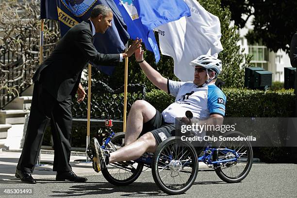 President Barack Obama gives a high-five to one of the participants during the seventh annual Wounded Warrior Project's Soldier Ride on the driveway...