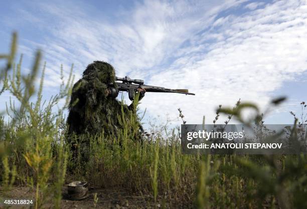 Ukrainian sniper holds on the position of Ukrainian forces on frontline in the Lugansk region on August 27, 2015. Ties between the EU and Russia...