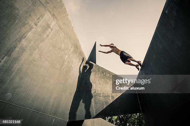 young man practicing parkour in the city - stunt person stock pictures, royalty-free photos & images
