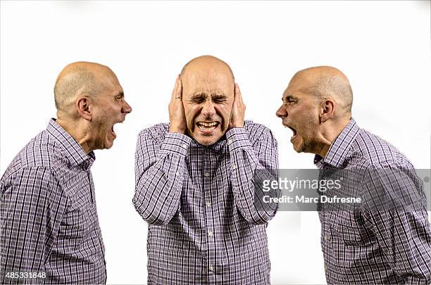 man covering his ears while other shouting - schizophrenia stock pictures, royalty-free photos & images