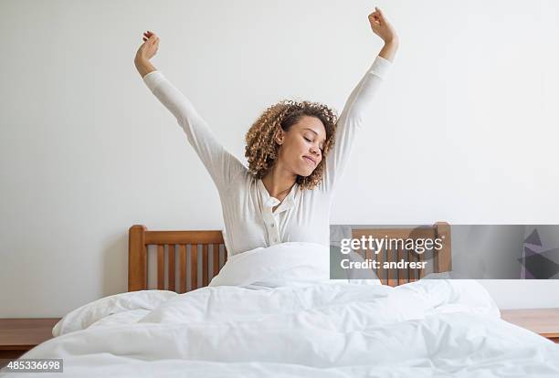 mujer bostezar en la cama - levantarse fotografías e imágenes de stock