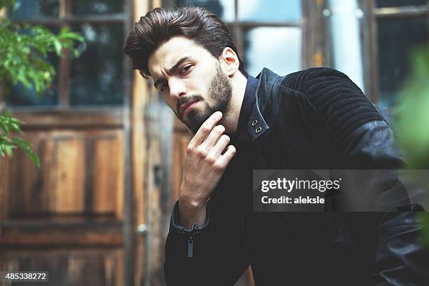 fashion portrait of a handsome bearded man - sekssymbool stockfoto's en -beelden