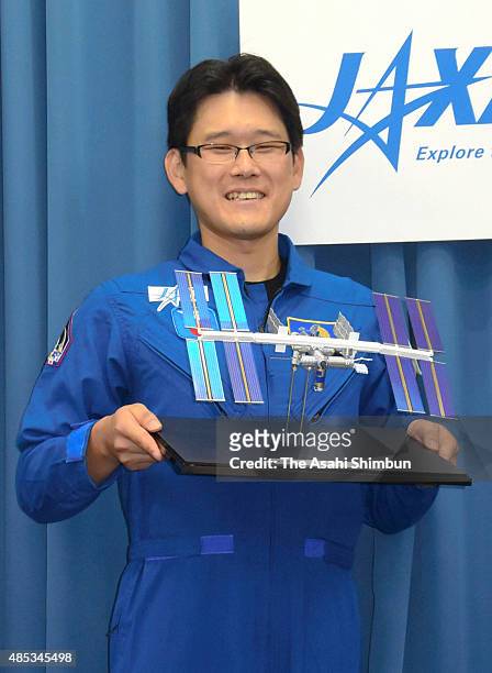 Japan Aerospace Exploration Agency astronaut Norishige Kanai poses for photographs during a press conference at the JAXA Tokyo office on August 27,...