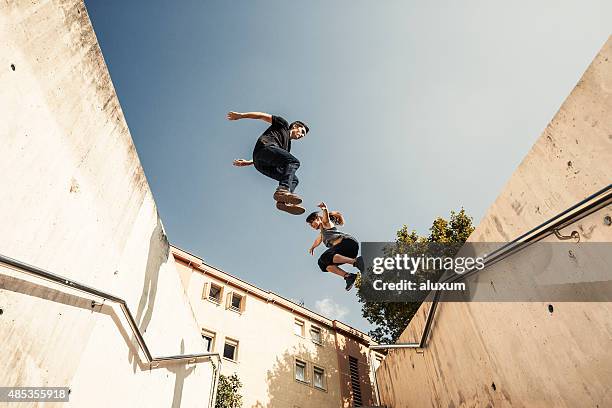 jumping and practicing parkour in the city - man jump outdoor young city stock pictures, royalty-free photos & images