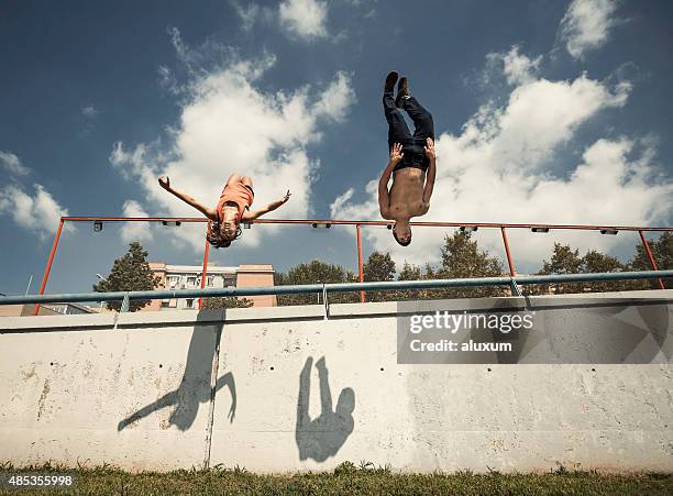 üben parkour- in der stadt frau und mann einen salto rückwärts - stuntman stock-fotos und bilder