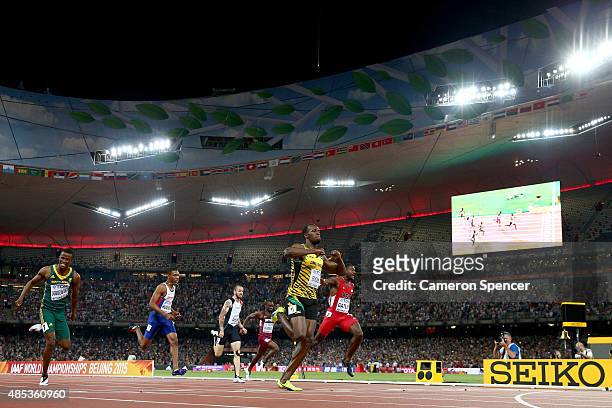 Usain Bolt of Jamaica crosses the finish line to win gold ahead of Justin Gatlin of the United States and Anaso Jobodwana of South Africa in the...