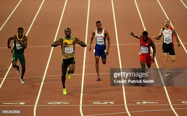 Usain Bolt of Jamaica crosses the finish line to win gold ahead of second place Justin Gatlin of the United States and Anaso Jobodwana of South...