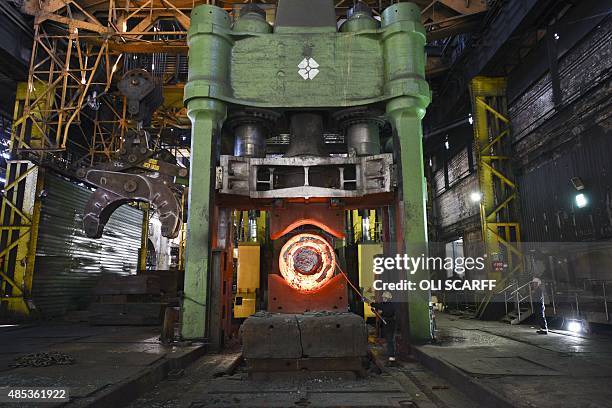Forgemen oversees the manipulation of a 100 tonne cylinder of freshly cast hot steel in the forge at Sheffield Forgemasters International Ltd. In...