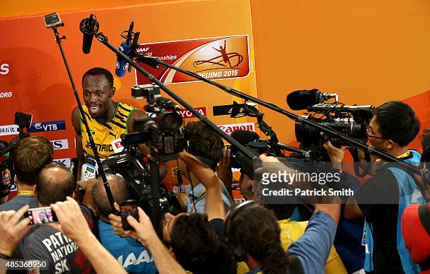 Usain Bolt of Jamaica speaks to the media after crossing the finish line to win gold in the Men's 200 metres final during day six of the 15th IAAF...