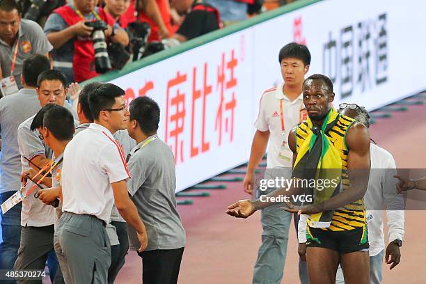 Security guards restrain a spectator on the track after he tried to approach Usain Bolt of Jamaica after he won gold in the Men's 200 metres final...