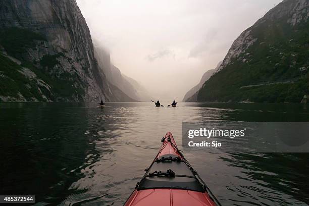 kayaking in a fjord in norway during twilight - kanoën stockfoto's en -beelden