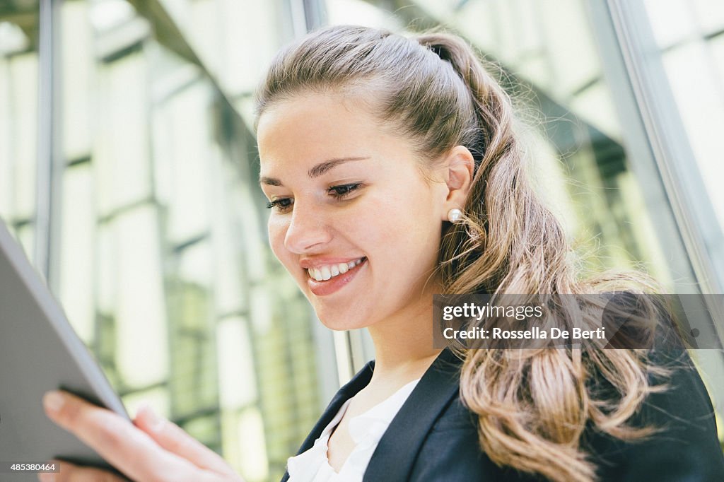 Allegra Donna d'affari utilizzando la tavoletta digitale in pausa caffè