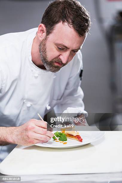 chef in a restaurant plating food - plats cuisines stock pictures, royalty-free photos & images