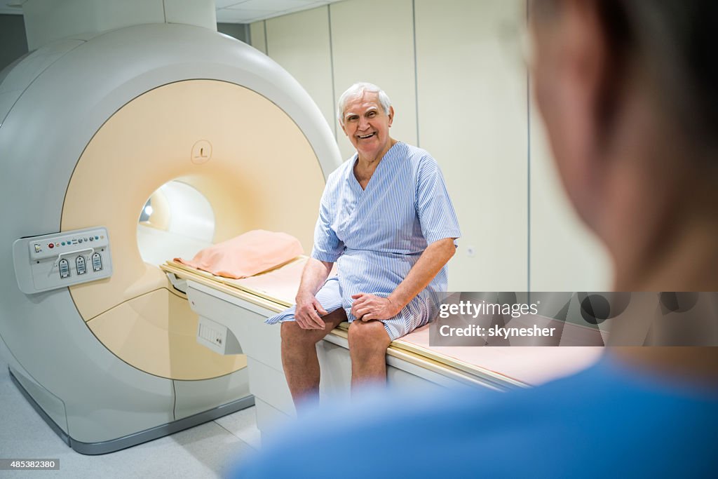 Happy senior patent after MRI scan looking at camera.