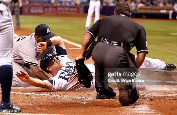 Home plate umpire Rob Drake looks on as Logan Forsythe of the Tampa Bay Rays scores in front of pitcher CC Sabathia of the New York Yankees after...