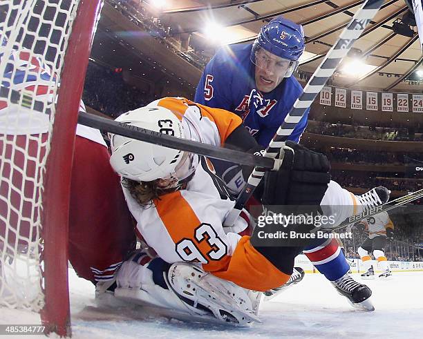 Jakub Voracek of the Philadelphia Flyers is taken down in the crease by Dan Girardi of the New York Rangers during the first period in Game One of...