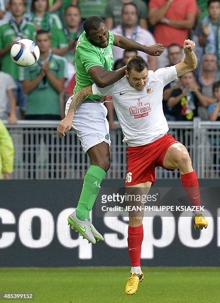 Saint-Etienne's French defender Kevin Theophile-Catherine jumps for the ball with Milsami Orhei's Romanian forward Cristian Bud during the UEFA...