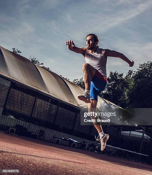 determinado jovem atleta masculina em um de salto em movimento. - mens long jump - fotografias e filmes do acervo