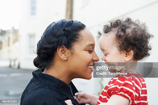 mother holding happy child - leanincollection foto e immagini stock