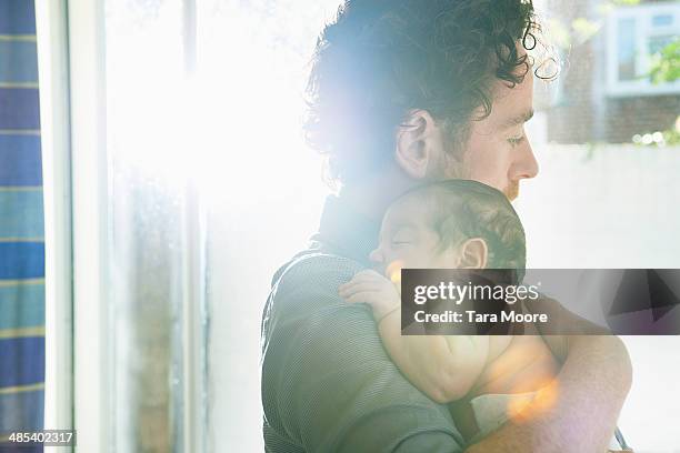 father holding baby - baby light stock-fotos und bilder